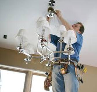 Electricians installing chandelier 